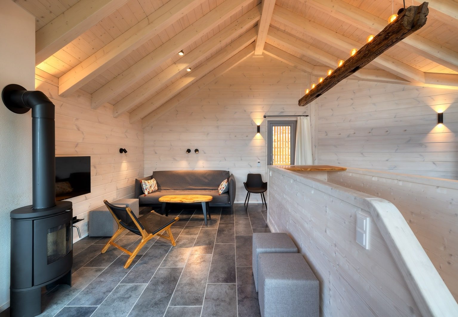 Wohnzimmer im Schwarzwald-Ferienhaus, ausgestattet mit einem Holzofen und einer bequemen Couch für entspannte Stunden.