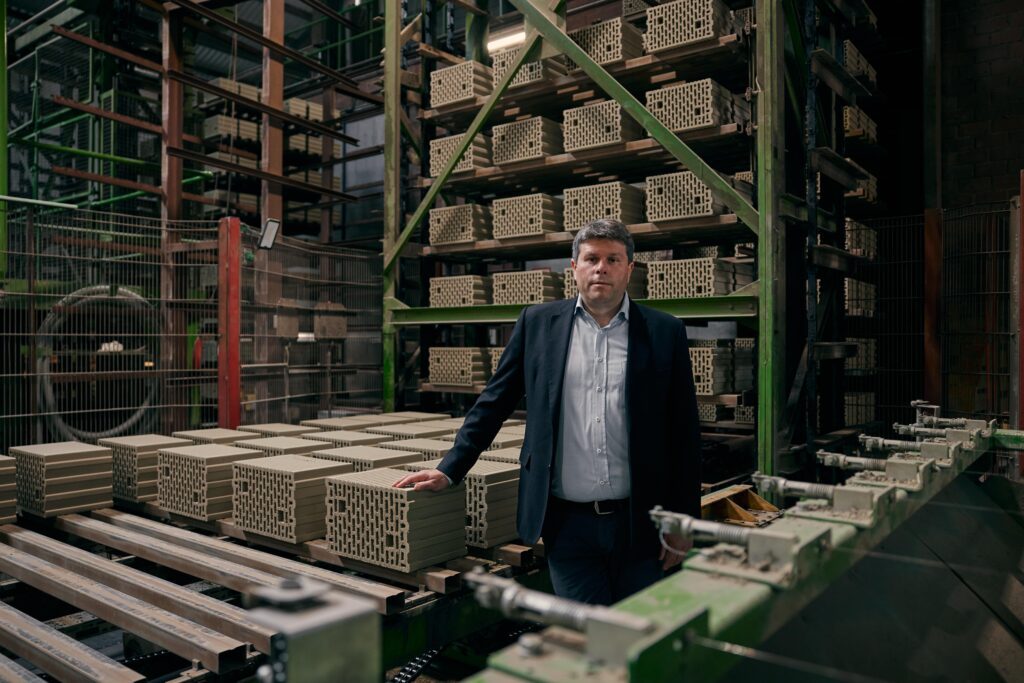 Modulare Bauweise: Thomas Bader im Ziegelwerk mit Mauerziegel für Module in Ziegelbauweise.